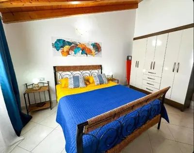 a bedroom with a blue and yellow bed in a room at Soleil A9 in Santa Maria