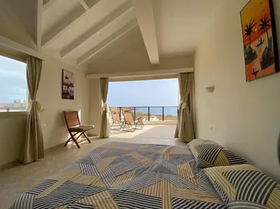 a bedroom with a bed and a view of the ocean at Surf House - Your Exclusive Getaway in Palmeira