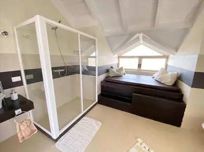 a small bathroom with a shower and a sink at Surf House - Your Exclusive Getaway in Palmeira