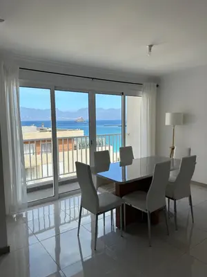 a dining room with a table and chairs and a balcony at Laginha Views in Mindelo