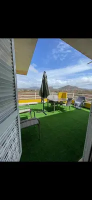 a patio with a table and chairs and an umbrella at La maison paisible in Malveira