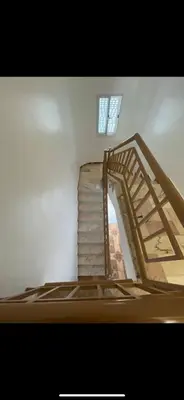 a wooden staircase in a room with a window at La maison paisible in Malveira