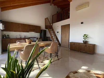 a kitchen and dining room with a wooden table and chairs at Estrela do Mar - Rooftop Ocean View in Santa Maria