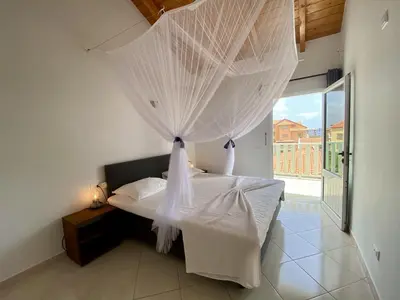a bedroom with a bed with white mosquito netting at Estrela do Mar - Rooftop Ocean View in Santa Maria
