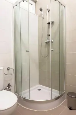 a shower with a glass door in a bathroom at 2 bdr cozy apt in Terra Branca, Free Wifi - LCGR in Praia