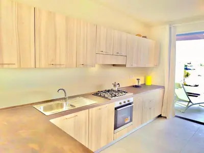 a kitchen with wooden cabinets and a sink and a stove at Stylish Lagoon Paradise Apartment Boa Vista in Sal Rei
