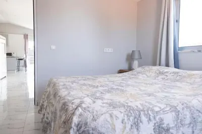 a bedroom with a bed with a floral blanket at 2 bdr cozy apartment in city center, Wifi - LCGR in Assomada