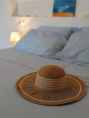 a straw hat sitting on top of a bed at Vila de Matiz in Vila do Maio