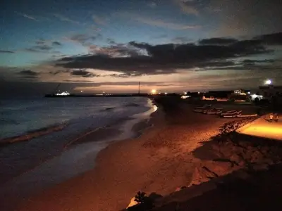 a beach at night with boats in the water at Vila de Matiz in Vila do Maio