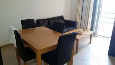 a dining room table with chairs and a couch at Central Studio Apartment near beach in Santa Maria