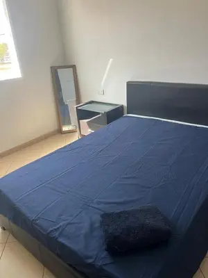 a large blue bed in a room with a table at Central Studio Apartment near beach in Santa Maria