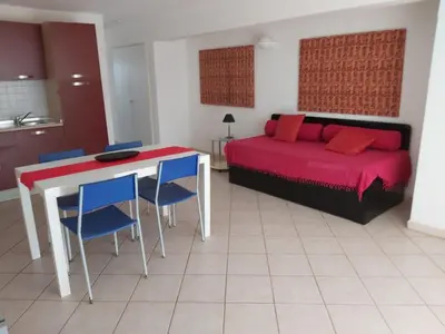 a bedroom with a bed and a table and chairs at Albis Harena - Leme Bedje Residence in Santa Maria