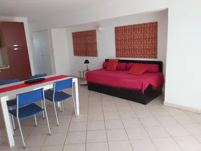 a bedroom with a bed and a table and chairs at Albis Harena - Leme Bedje Residence in Santa Maria