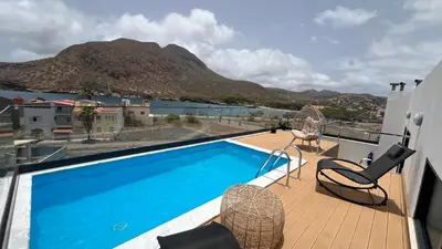 a balcony with a swimming pool and a view of a mountain at CasaZina in Tarrafal