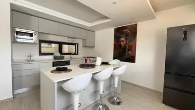 a kitchen with a counter with stools in it at CasaZina in Tarrafal