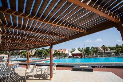 a view of the pool at a resort with a wooden pergola at Murdeira Village in Beirona