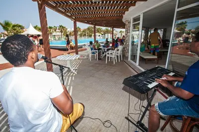 a man playing a keyboard in front of a musician at Murdeira Village in Beirona