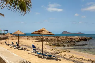 a group of chairs and umbrellas on a beach at Murdeira Village in Beirona