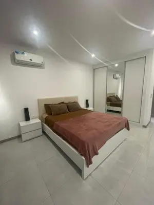 a bedroom with a large bed in a white room at Appartement standing praia in Praia