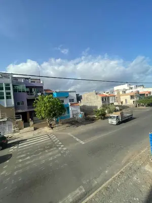 an empty street in a city with buildings and a truck at Appartement standing praia in Praia
