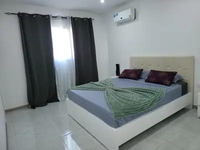 a bedroom with a bed with purple pillows and a window at Appartement standing praia in Praia