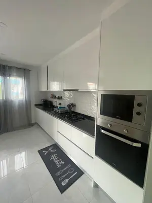 a white kitchen with a stove and a microwave at Appartement standing praia in Praia