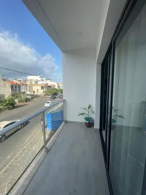 a room with a balcony with a view of a street at Appartement standing praia in Praia