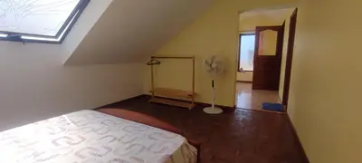 a attic room with a bed and a fan at Casa TIANA in Mindelo