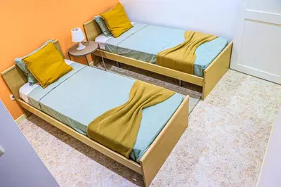 two twin beds in a room with a table at Coração de Santa Maria in Santa Maria