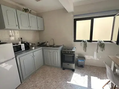 a kitchen with white cabinets and a stove and a window at Coração de Santa Maria in Santa Maria