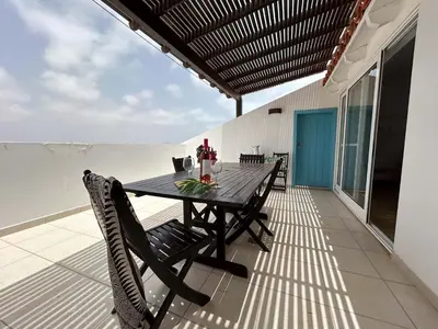 a black table and chairs on a balcony with the ocean at Un hogar lejos de tu hogar in Sal Rei