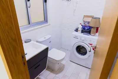 a bathroom with a toilet and a washing machine at Jet Ap & Car 23 in Praia