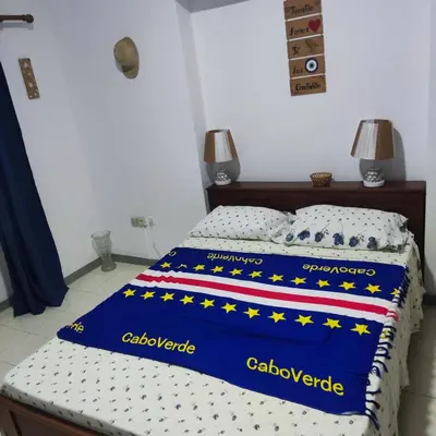 a bed with a blue blanket with stars on it at Casa fréd in Mindelo