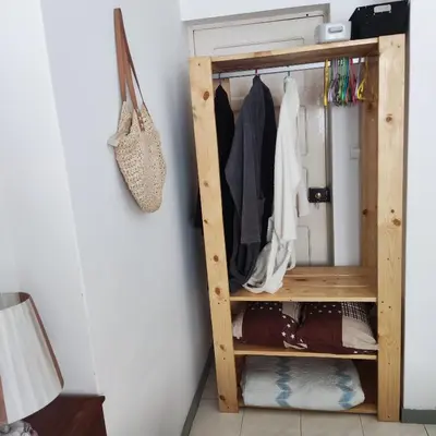 a closet with a wooden shelf with clothes at Casa fréd in Mindelo