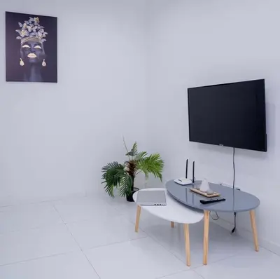 a living room with a table and a flat screen tv at Nikita in Praia