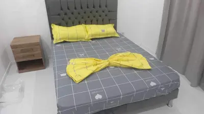 a bed with a yellow bow tie on it at Nikita in Praia