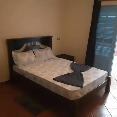 a bedroom with a bed with a black shirt on it at Padaria Portuguesa, with porch facing the street in Santa Maria