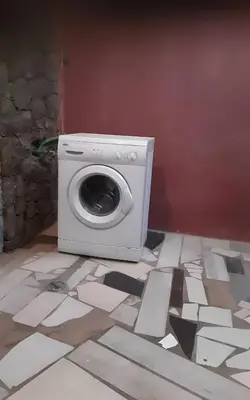 a washing machine sitting on a floor in a room at Padaria Portuguesa, with porch facing the street in Santa Maria
