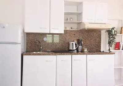 a white kitchen with white cabinets and a sink at Vista Mar - Seafront Holiday Apartments in Santa Maria