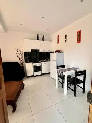 a kitchen with white appliances and a table in it at Oásis de retour in Ponta do Sol