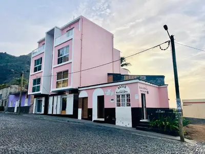 a pink building on the side of a street at Oásis de retour in Ponta do Sol