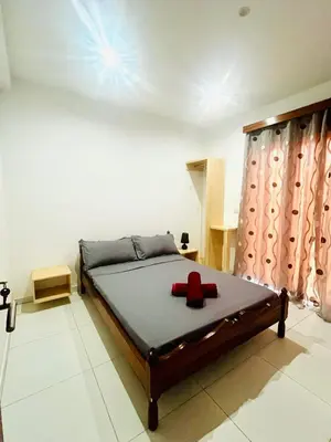 a bedroom with a bed with a red cross on it at Oásis de retour in Ponta do Sol