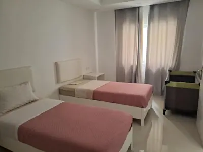 a hotel room with two beds and a window at Bela's house in Mindelo