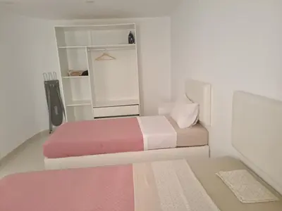 a small bedroom with two beds and a mirror at Bela's house in Mindelo