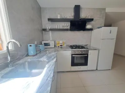 a kitchen with a sink and a stove and refrigerator at Bela's house in Mindelo