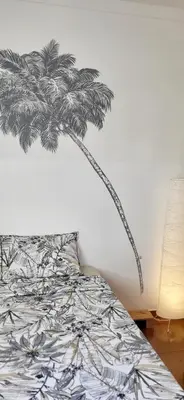 a bedroom with a bed with a palm tree mural on the wall at Surfhouse Boavista in Sal Rei