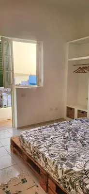 a bedroom with a large bed with a window at Surfhouse Boavista in Sal Rei