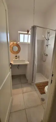 a bathroom with a shower and a sink and a mirror at Surfhouse Boavista in Sal Rei
