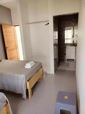 a bedroom with a bed and a door to a bathroom at Hostel Rocha Marisol in Ponta do Sol
