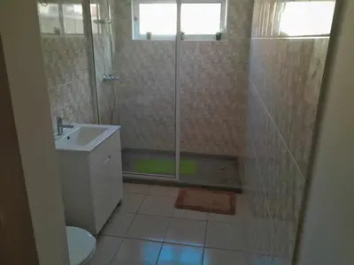 a bathroom with a shower and a toilet and a sink at Hostel Rocha Marisol in Ponta do Sol
